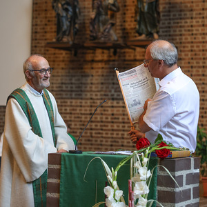 Pfarrmoderator Bräuer bekam eine Tageszeitung vom Tag der Priesterweihe überreicht.