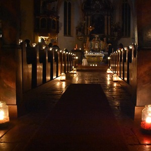 Bußandacht in der nur mit Kerzen erleuchteten Kirche