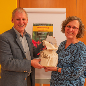 Ermutigung für eine zukunftsfähige Kirche - Dekanats Windischgarsten lud zu einem AbendBild: Univ.-Prof. Dr. Franz Gruber erhält von Susanne Lammer, Dekanatsassistentin, zum Dank ein Bschoadbinkerl