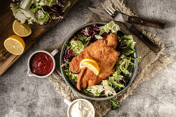 Crispy breadead schnitzel with salad and mayo sauce