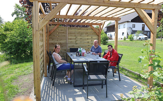 Bewohner in Pfaffing genießen den Sommer unter der neuen Pergola / © Caritas Bewohner in Pfaffing genießen den Sommer unter der neuen Pergola