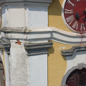 Am Glockenturm bröckelt der Putz, das Ziffernblatt der Turmuhr verliert Farbe. Auch die Zeiger sind alt und brüchig.