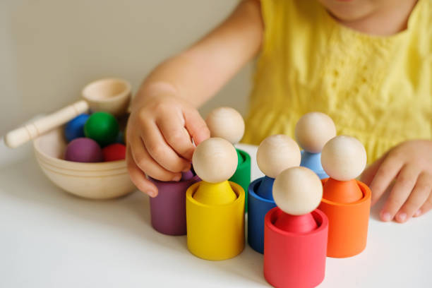 A modern creative toy sorter made of wood, for studying flowers by preschoolers. Figurines in the form of little men in cups