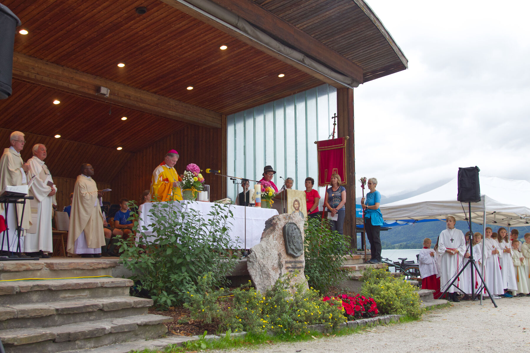 Die Pilgerbegleiter:innen bringen die Fürbitten beim Pilgergottesdienst an der Seepromenade in St. Wolfgang dar.