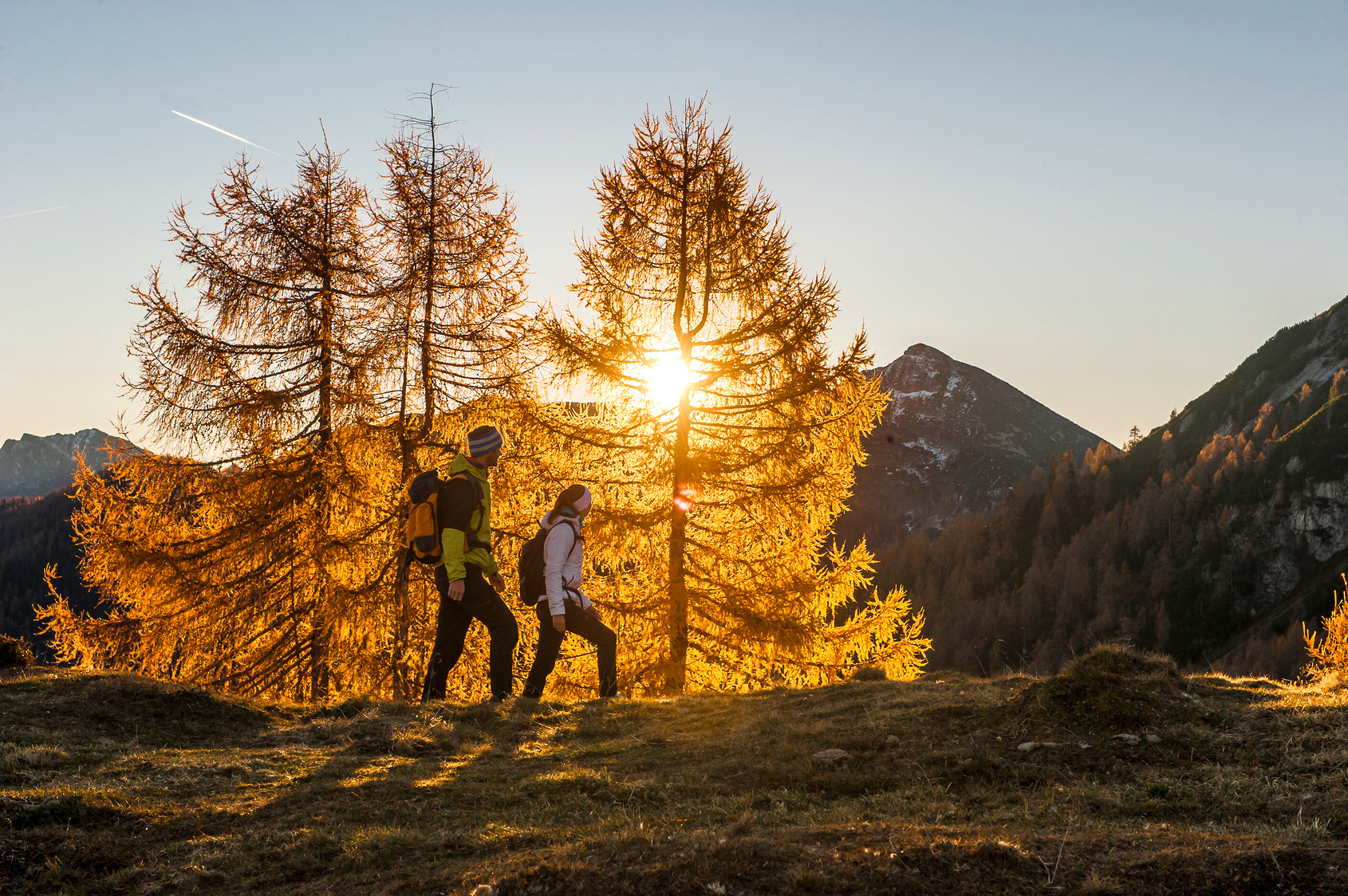Two people hiking in Ennstal Alps at autumn sunset