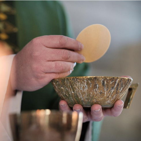 Hostie in der Hand des Priesters