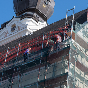 Am Gerüst sind Jakob Haijes, Pfarrgemeinderats-Obmann, er reinigt mit seinem Bruder Samuel die Dachrinne, Vater Jack fertigt davon Fotos an