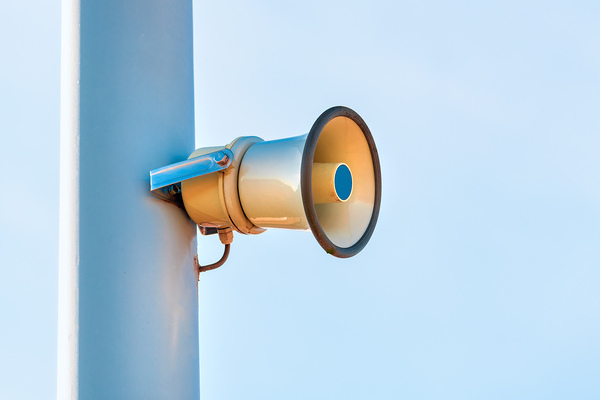 Street loudspeaker megaphone mounted on the post with clear sky as copy space