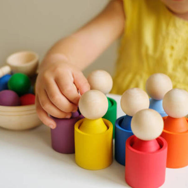 A modern creative toy sorter made of wood, for studying flowers by preschoolers. Figurines in the form of little men in cups