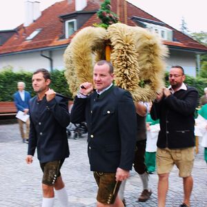 Vier Bauern tragen die Erntekrone