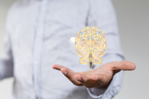 A male's hand holding an illustrated golden digital brain