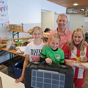 Kinder freuen sich mit Organisator Hans Scheibl über die Tombola